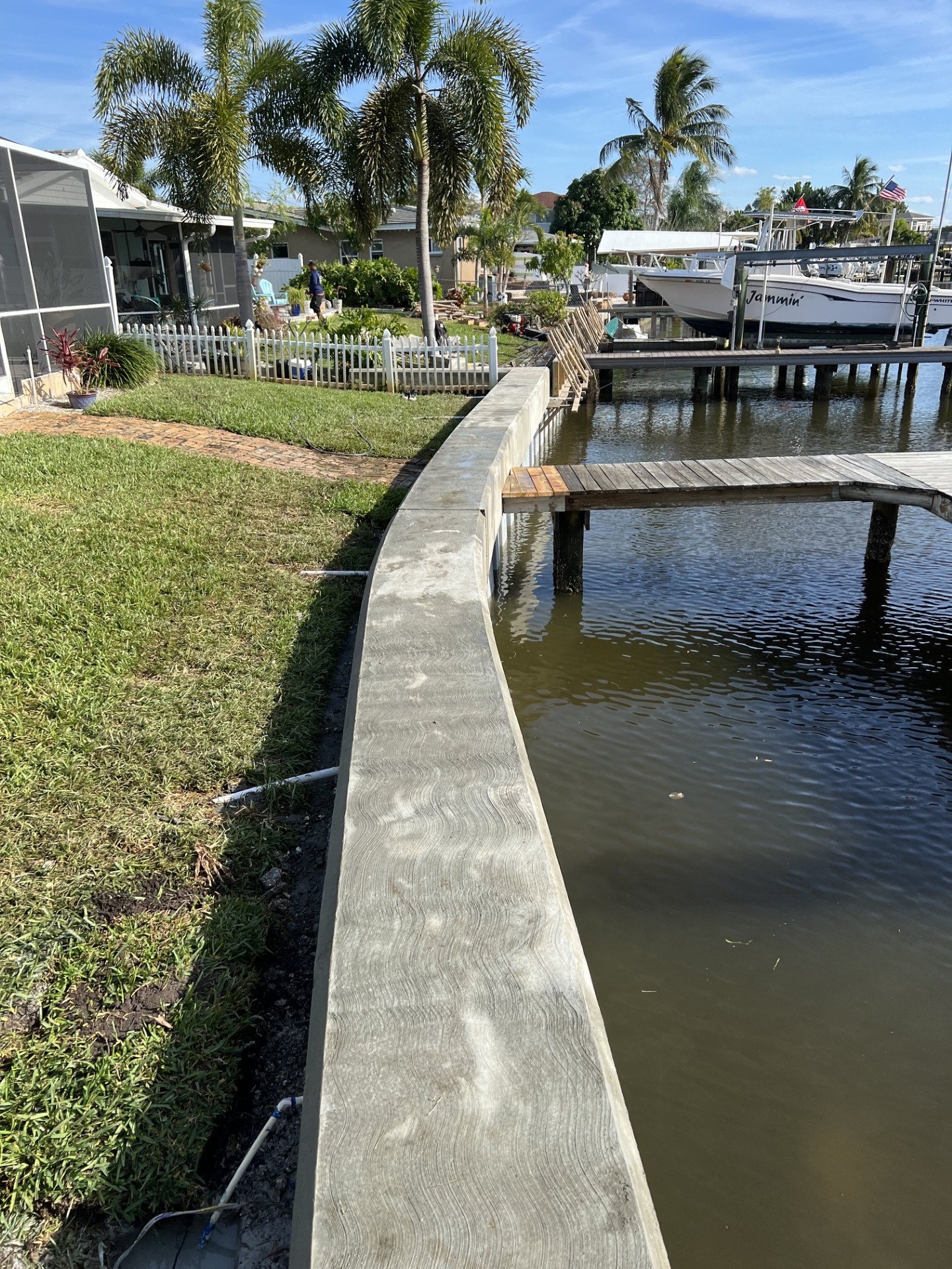 Curved concrete seawall on open bay frontage